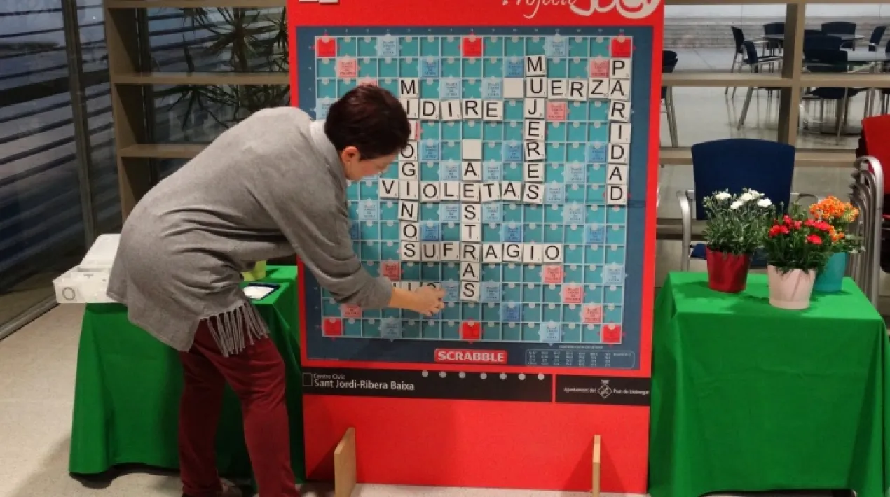 Per celebrar i reivindicar el Dia Internacional de les Dones, les entitats vinculades el Centre C&iacute;vic Sant Jordi-Ribera Baixa i altres col&middot;lectius de la ciutat ofereixen una programaci&oacute; especial. Durant tot un mes obren portes dels seus tallers -on la majoria, si no&nbsp;la totalitat&nbsp;de participants, s&oacute;n dones-, adapten les seves activitats habituals a tem&agrave;tiques de g&egrave;nere i ofereixen noves propostes per endinsar-nos en la reflexi&oacute; entorn a les dones. El Club Scrabble El Prat es troba cada primer dimarts de mes i ofereix, a tothom qui vulgui venir, la possibilitat d'aprendre a jugar a aquest joc m&iacute;tic i passar una bona estona.&nbsp;En aquesta ocasi&oacute; la tem&agrave;tica concreta ser&agrave; tot el relacionat amb les dones.&nbsp; L'Scrabble &eacute;s un joc de tauler ling&uuml;&iacute;stic. L'objectiu &eacute;s acumular la m&agrave;xima puntuaci&oacute; possible formant paraules en una graella de 15&times;15 caselles, algunes d'elles bonificades, fent servir fitxes individuals que s'agafen aleat&ograve;riament d'un saquet o bossa. Tot un repte que engresca a qualsevol!&nbsp;Veure m&eacute;s