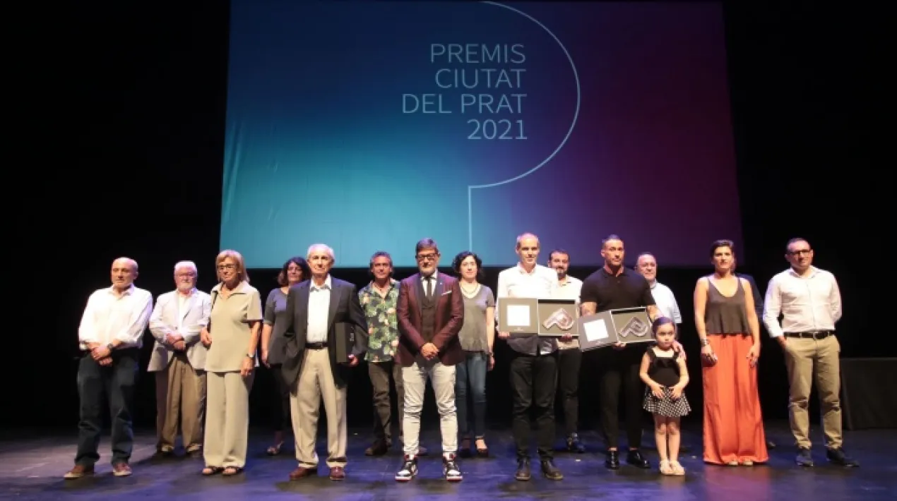  El Teatre L’Artesà ha acollit aquest divendres, 2 de juliol, a la tarda l’acte de lliurament dels XII Premis Ciutat del Prat. En aquesta edició, els premiats han estat l’assemblea local de la Creu Roja al Prat,  per la seva aportació altruista a la comunitat i el seu compromís amb les persones en situació vulnerable; Cristina BanBan, en reconeixement dels seus mèrits com a artista plàstica i la seva contribució a la cultura; i Vicenç Lluch Beltrán, per tota una vida dedicada a la integració i visibilitat de les persones amb diversitat funcional. Amb aquests premis, que es van instaurar l'any 2009 i que a partir d'ara es faran cada dos anys, es vol reconèixer la trajectòria i les aportacions de persones o organitzacions vinculades al Prat, que hagin contribuït a fomentar la llibertat, la solidaritat, la igualtat i el progrés de la societat en qualsevol àmbit, hagin destacat en qualsevol disciplina cultural o esportiva o contribuït a projectar i donar prestigi al nom de la ciutat. En l’acte de lliurament dels premis d’enguany, l’alcalde del Prat, Lluís Mijoler, ha entregat personalment el guardó a Vicenç Lluch Beltrán i l’equip de la Creu Roja, representat per Jordi Hueto, president de l’assemblea local del Prat; Josep Quitet, president de la institució humanitària a Catalunya, i Ester López, referent tècnica de l’entitat a la ciutat. En el cas de Cristina BanBan, que treballa a Nova York, no ha pogut assistir personalment a l’acte, però ha dirigit un missatge en vídeo al públic. Ha recollit el premi el seu germà. L’acte de lliurament dels XII Premis Ciutat del Prat, emès en directe pel prat.tv, ha estat conduït per Víctor Asensio de El Prat Comunicació. També ha comptat amb l’amenització musical de Dream Big Band. La trajectòria dels premiats i premiades   L’assemblea local de la Creu Roja al Prat, l’origen de la qual a la nostra ciutat es remunta a l’any 1904, està formada majoritàriament per persones voluntàries. Els principis que regeixen la seva activitat  estan orientats a donar ajut i suport a les persones en risc de pobresa i exclusió social, promovent la igualtat d’oportunitats i la lluita contra la discriminació. Entre les diferents tasques que desenvolupa l’entitat a la ciutat, destaca la col·laboració estable i continuada amb l’Ajuntament del Prat, en els àmbits d’atenció a la infància i a les famílies en situació vulnerable, en el suport a la gent gran i en matèria de salut pública. A més, la seva tasca social, humanitària i de comunicació durant la pandèmia ha estat exemplar i molt necessària a la ciutat, clau en la dinamització activa de la ciutadania, que s’ha implicat de forma voluntària per donar suport als col·lectius amb més dificultats.   Cristina BanBan (nom artístic de Cristina Martín Collado) és una artista pratenca nascuda el 1987, de destacada i reconeguda trajectòria internacional. Va iniciar la seva formació artística a l’Escola d’Arts del Prat, on va passar d’alumna a professora, i és llicenciada en Belles Arts per la Universitat de Barcelona. Actualment viu i treballa a Nova York. Les seves pintures exploren la forma del cos humà, superant els límits de les proporcions amb la representació de figures femenines voluptuoses, combinant harmoniosament el real i l’imaginari, amb escenes íntimes quotidianes que parlen sobre les expectatives socials, les normes i els valors que envolten la feminitat i la vida dels millennials en l’era de la tecnologia. Al 2017, va ser reconeguda com a millor artista jove amb el premi Arts Club de la Real Acadèmia de Londres i ha rebut grans elogis per part de la crítica internacional especialitzada. Ha col·laborat amb reconeguts artistes nacionals i internacionals i ha exposat de forma individual o col·lectiva la seva obra en galeries d’arreu del món. Aquest 2021, ha exposat a la 1969 Gallery de Nova York, al Museu d’Art de Columbus Ohio, al Kunstraum Potsdam d’Alemanya i està preparant una exposició a la Xina per al setembre.   Vicenç Lluch Beltrán va néixer a Santa Magdalena de Pulpis (Castelló) l’any 1935, però ha viscut la major part de la seva vida al Prat. A la nostra ciutat, ha tingut una gran implicació amb el món associatiu i ha destacat per la seva faceta voluntària.  En l’àmbit esportiu, va portar equips de bàsquet de La Seda de Barcelona durant 10 anys. En l’àmbit social, va formar part d’aquells primers pares i mares que van iniciar-se en la lluita i defensa dels seus fills i filles amb discapacitat intel·lectual. Va formar part de l’Escola Sant Isidre i va participar en la junta formadora de la Fundació Rubricatus. Va ser vicepresident de l’entitat fins a l’any 2019 i va impulsar el Taller especial de Treball TESIPRAT. En l’àmbit associatiu, va ser un dels fundadors de l’Associació de Veïns de la Barceloneta. Forma part encara de la seva junta i és membre actiu del barri.Veure més